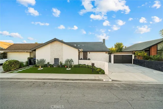 a view of a house with a yard and potted plants