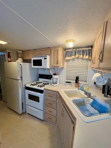 a kitchen with stainless steel appliances a stove a refrigerator and a dining table