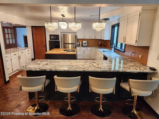 a kitchen with kitchen island granite countertop a sink stove and refrigerator