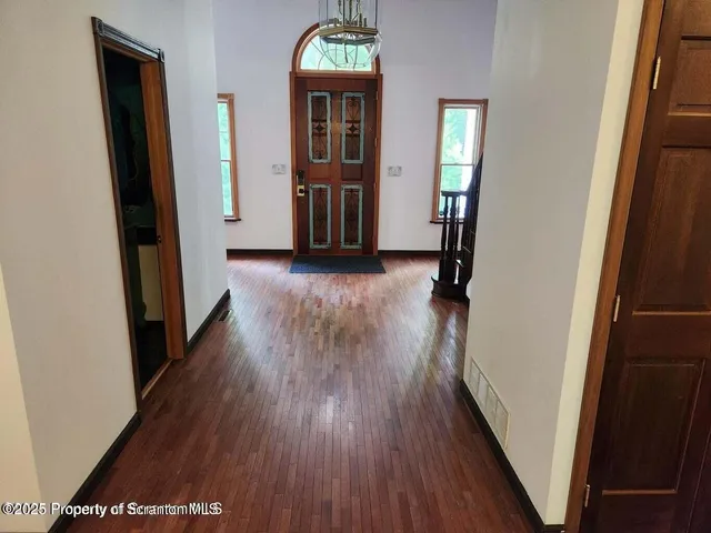 a view of a hallway with wooden floor and stairs
