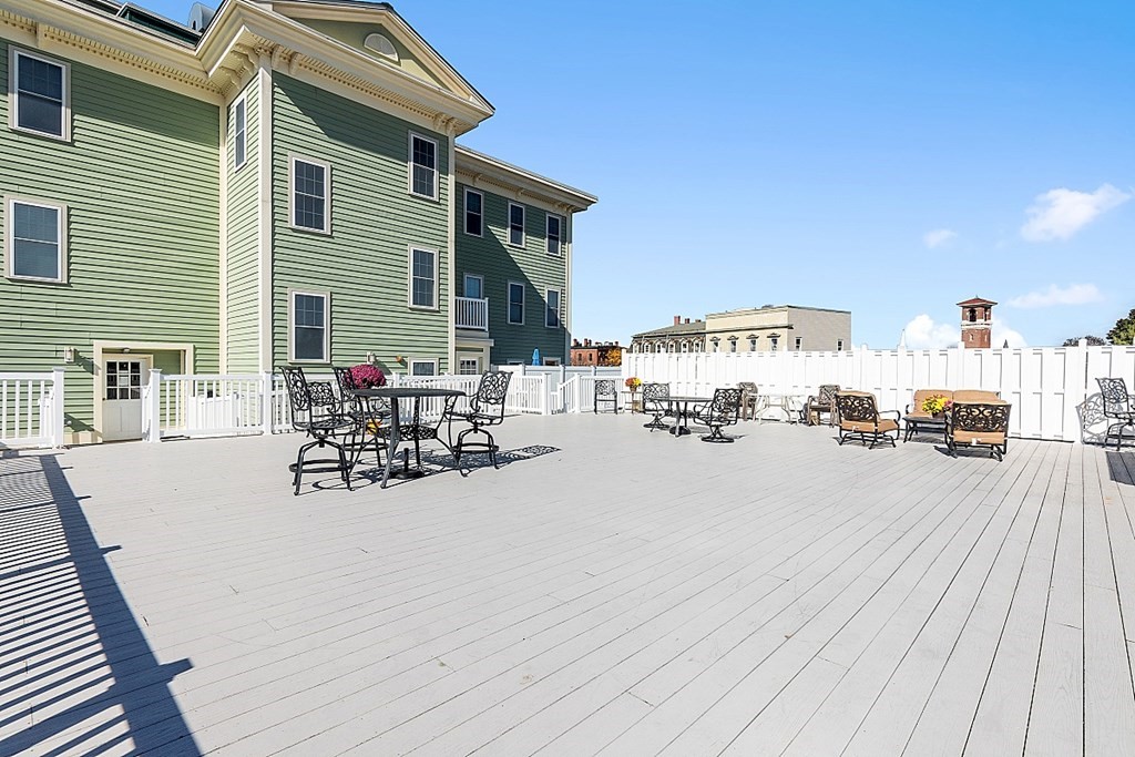 426 Main Street, Unit 205 Melrose, MA 02176 - Photo 19 of 26 a view of a patio with dining table and chairs with wooden floor