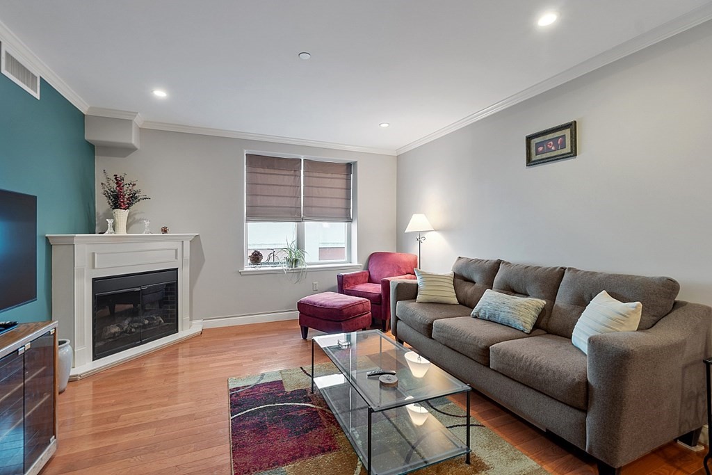 426 Main Street, Unit 205 Melrose, MA 02176 - Photo 7 of 26 a living room with furniture or window and a fireplace