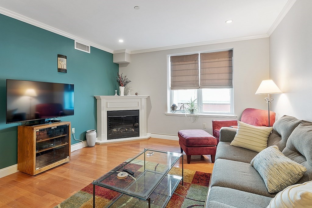 426 Main Street, Unit 205 Melrose, MA 02176 - Photo 8 of 26 a living room with furniture a flat screen tv and a fireplace