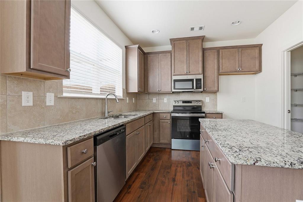 7641 Squire Court Fairburn, GA 30213 - Photo 11 of 33 a kitchen with stainless steel appliances granite countertop a sink stove and refrigerator