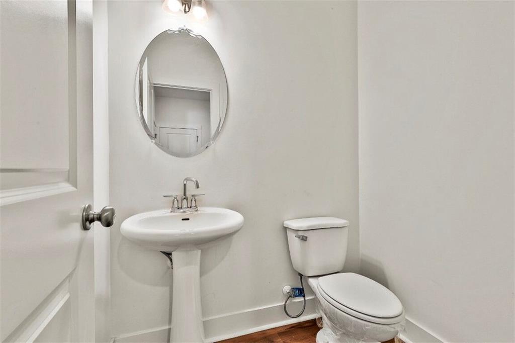 7641 Squire Court Fairburn, GA 30213 - Photo 18 of 33 a bathroom with a toilet a sink and mirror
