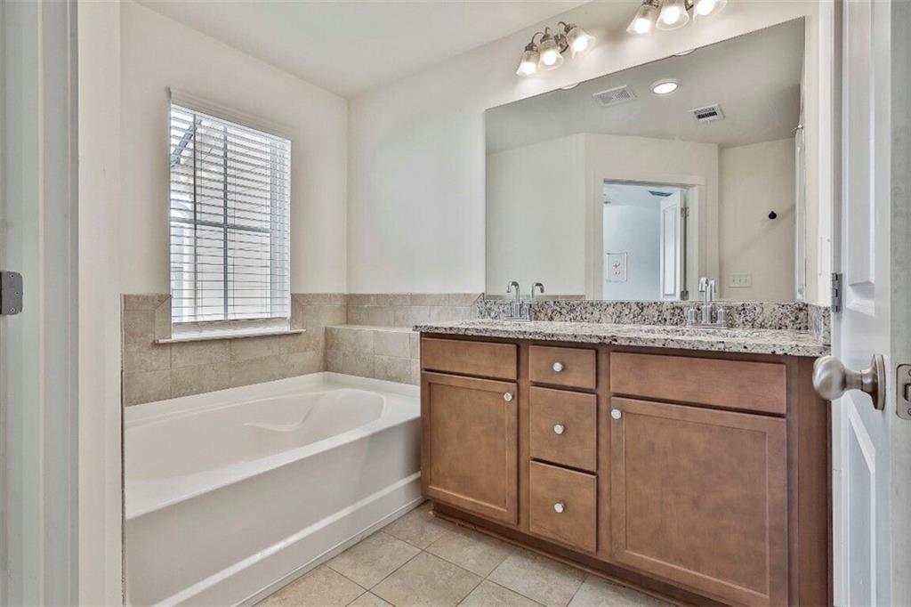 7641 Squire Court Fairburn, GA 30213 - Photo 24 of 33 a bathroom with a granite countertop tub sink and mirror