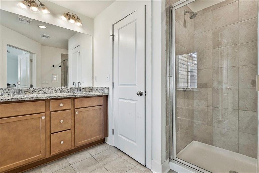 7641 Squire Court Fairburn, GA 30213 - Photo 25 of 33 a bathroom with a granite countertop sink two mirror and shower