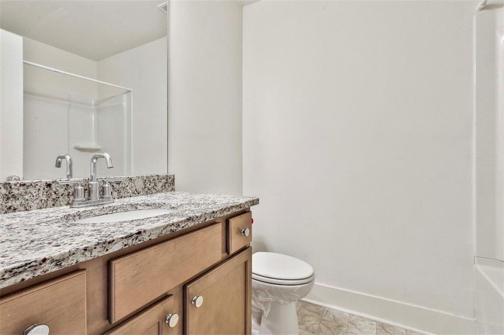 7641 Squire Court Fairburn, GA 30213 - Photo 28 of 33 a bathroom with a granite countertop sink and a toilet