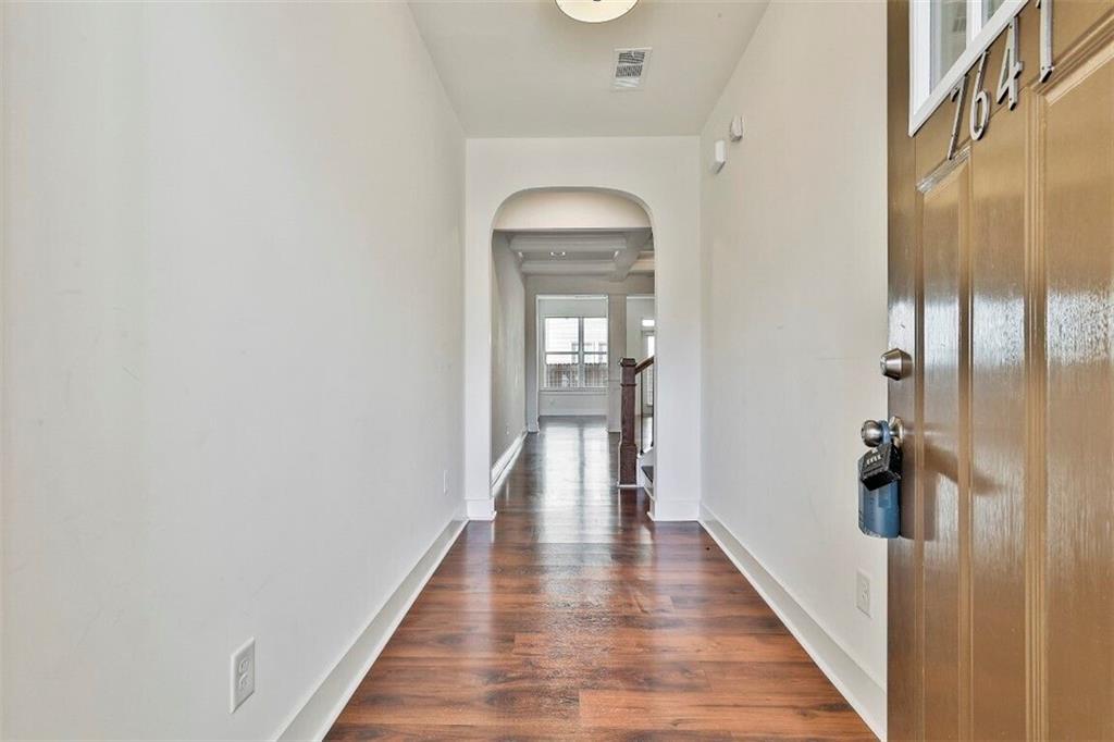 7641 Squire Court Fairburn, GA 30213 - Photo 4 of 33 a hallway with wooden floor windows and a bathroom