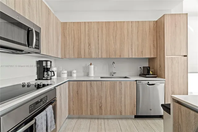 a kitchen with stainless steel appliances a stove a sink and cabinets