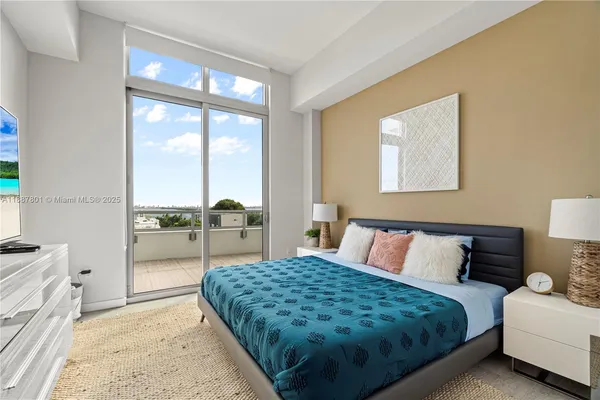 a bedroom with a bed and a large window