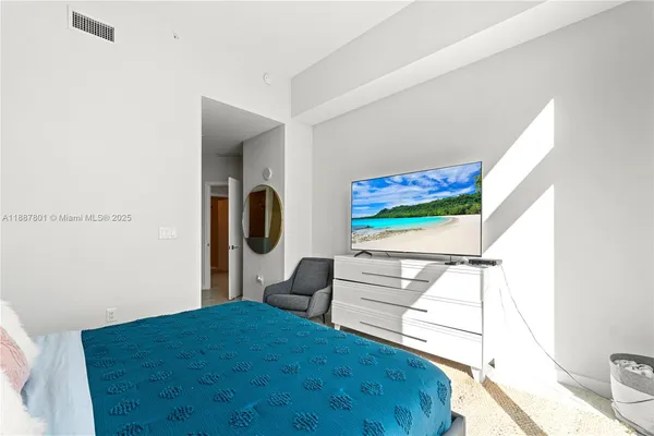 a bedroom with a bed and a flat screen tv