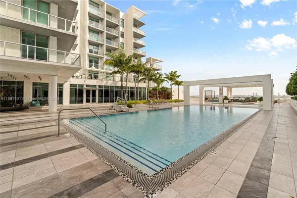 a view of a swimming pool with a bench in front of building