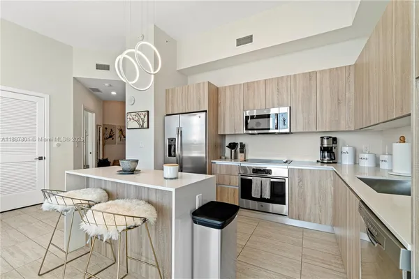 a kitchen with stainless steel appliances a stove sink microwave refrigerator and cabinets