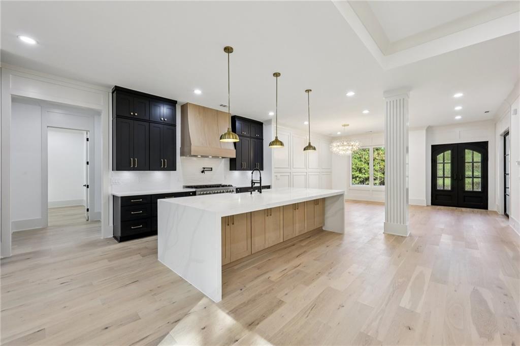 3209 Bold Springs Road Dacula, GA 30019 - Photo 14 of 62 a large kitchen with stainless steel appliances kitchen island a large counter top and a wooden floors