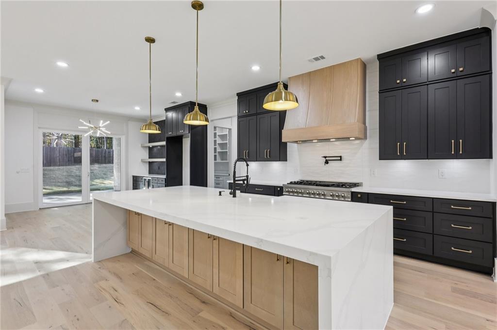 3209 Bold Springs Road Dacula, GA 30019 - Photo 18 of 62 a large kitchen with kitchen island a stove a sink a center island and wooden floor