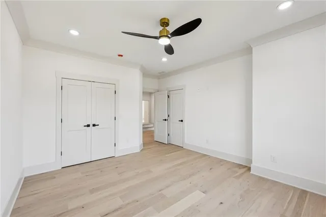 wooden floor in an empty room with a ceiling fan
