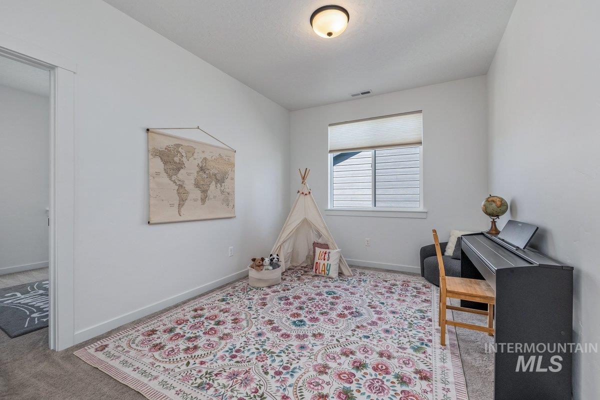 1380 West Chilitna Street Meridian, ID 83642 - Photo 38 of 50 Spacious room featuring neutral painted walls, light gray carpet, a single window with blinds, and a flush-mount ceiling light fixture