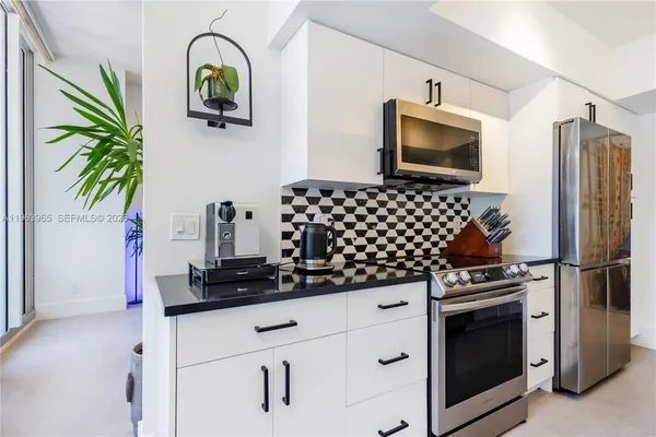 a kitchen with appliances a counter space and cabinets