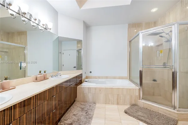 a bathroom with a double vanity sink mirror and shower