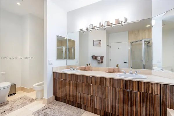 a bathroom with a double vanity sink mirror and toilet