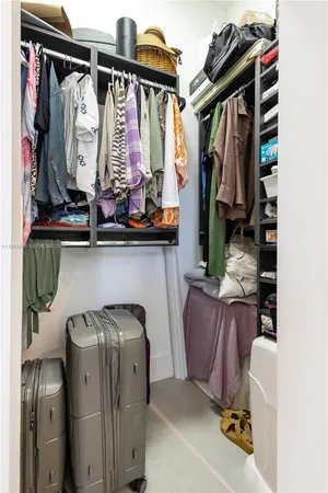 a view of walk in closet with clothes and shoes