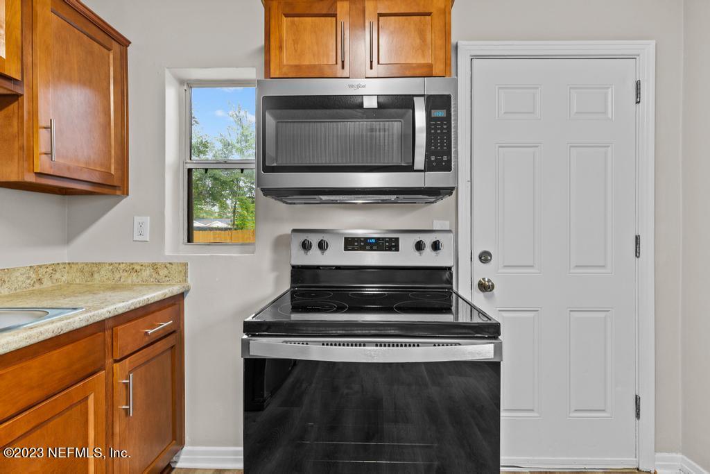 1023 Seba Street Jacksonville, FL 32205 - Photo 15 of 27 a kitchen with granite countertop white cabinets and appliances