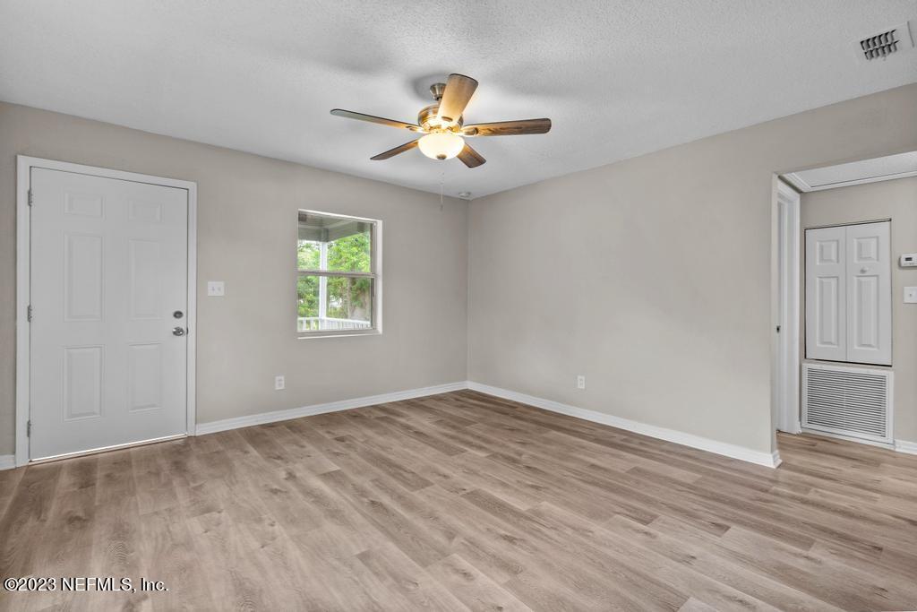 1023 Seba Street Jacksonville, FL 32205 - Photo 9 of 27 an empty room with wooden floor chandelier fan and windows