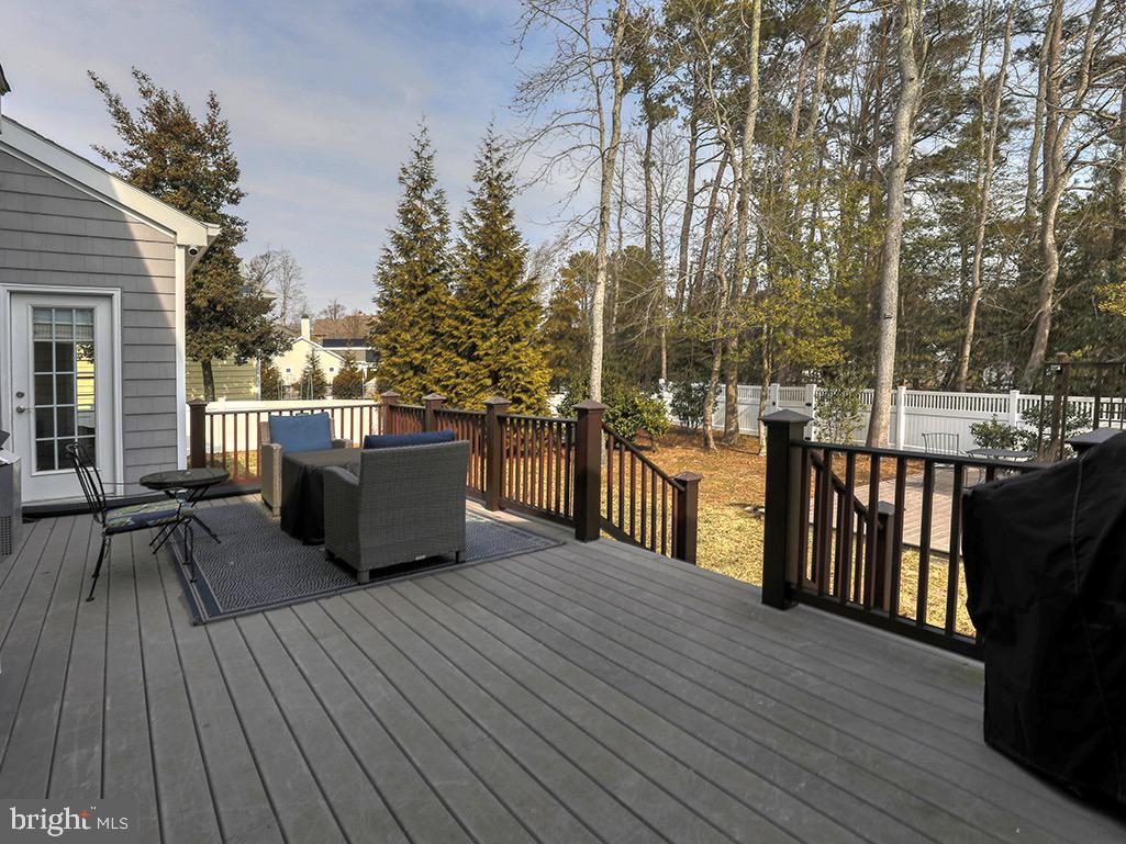 135 Cornwall Road Rehoboth Beach, DE 19971 - Photo 13 of 101 a view of a roof deck with table and chairs a barbeque with wooden floor and fence