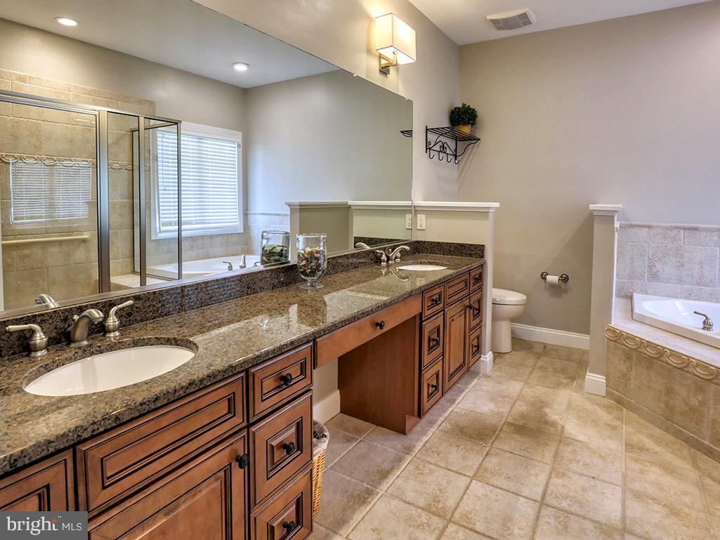 135 Cornwall Road Rehoboth Beach, DE 19971 - Photo 37 of 101 a spacious bathroom with a granite countertop sink a mirror and a