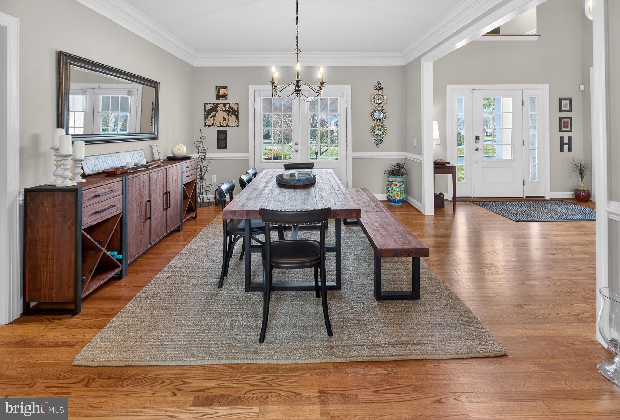 135 Cornwall Road Rehoboth Beach, DE 19971 - Photo 42 of 101 a dining room with wooden floor a chandelier a wooden table and chairs