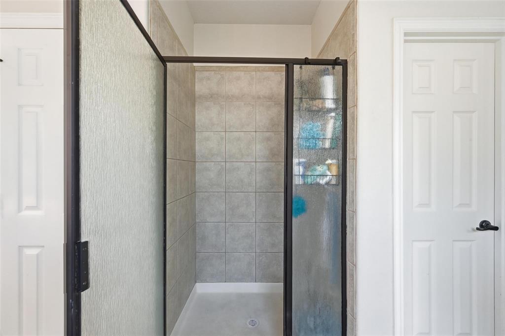 2319 Goshawk Street Grand Prairie, TX 75052 - Photo 20 of 40 a bathroom with a glass shower door
