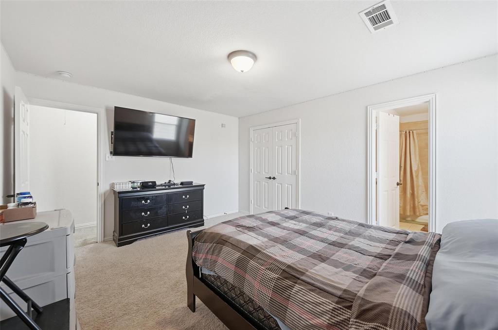 2319 Goshawk Street Grand Prairie, TX 75052 - Photo 28 of 40 a bedroom with a bed and a flat screen tv