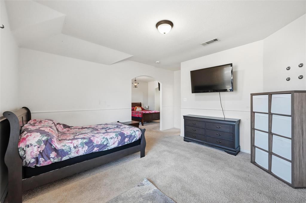 2319 Goshawk Street Grand Prairie, TX 75052 - Photo 33 of 40 a bedroom with a bed and a flat screen tv