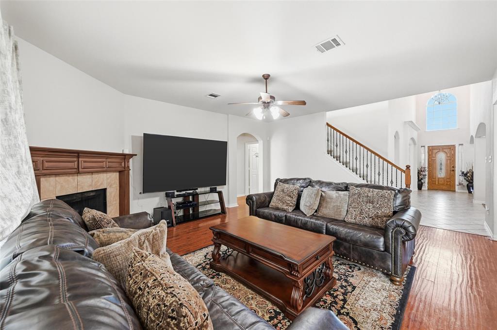 2319 Goshawk Street Grand Prairie, TX 75052 - Photo 10 of 40 a living room with furniture a fireplace and a flat screen tv