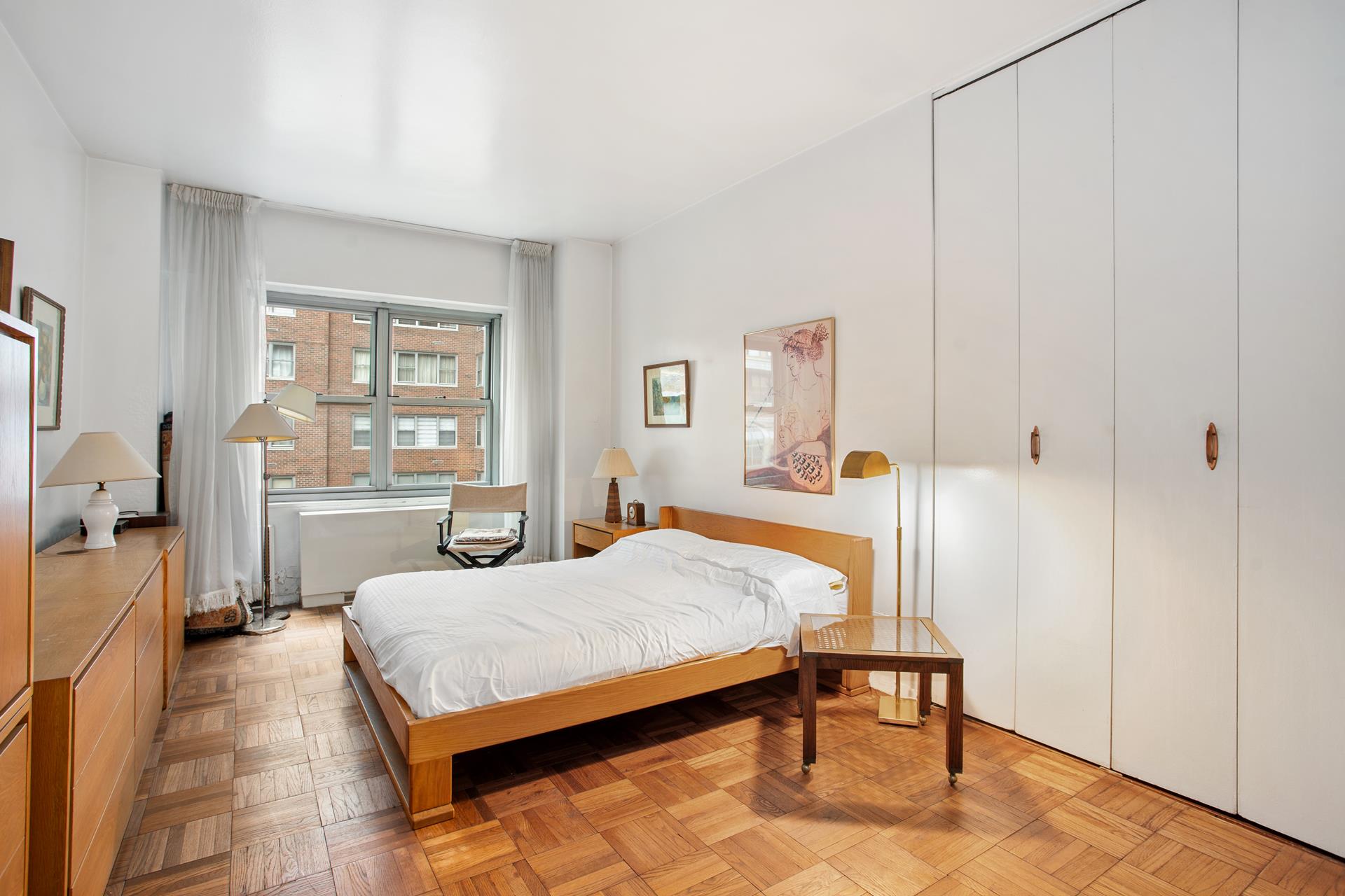 360 East 72nd Street, Unit B804 Manhattan, NY 10021 - Photo 4 of 17 a bedroom with a bed and a table in it