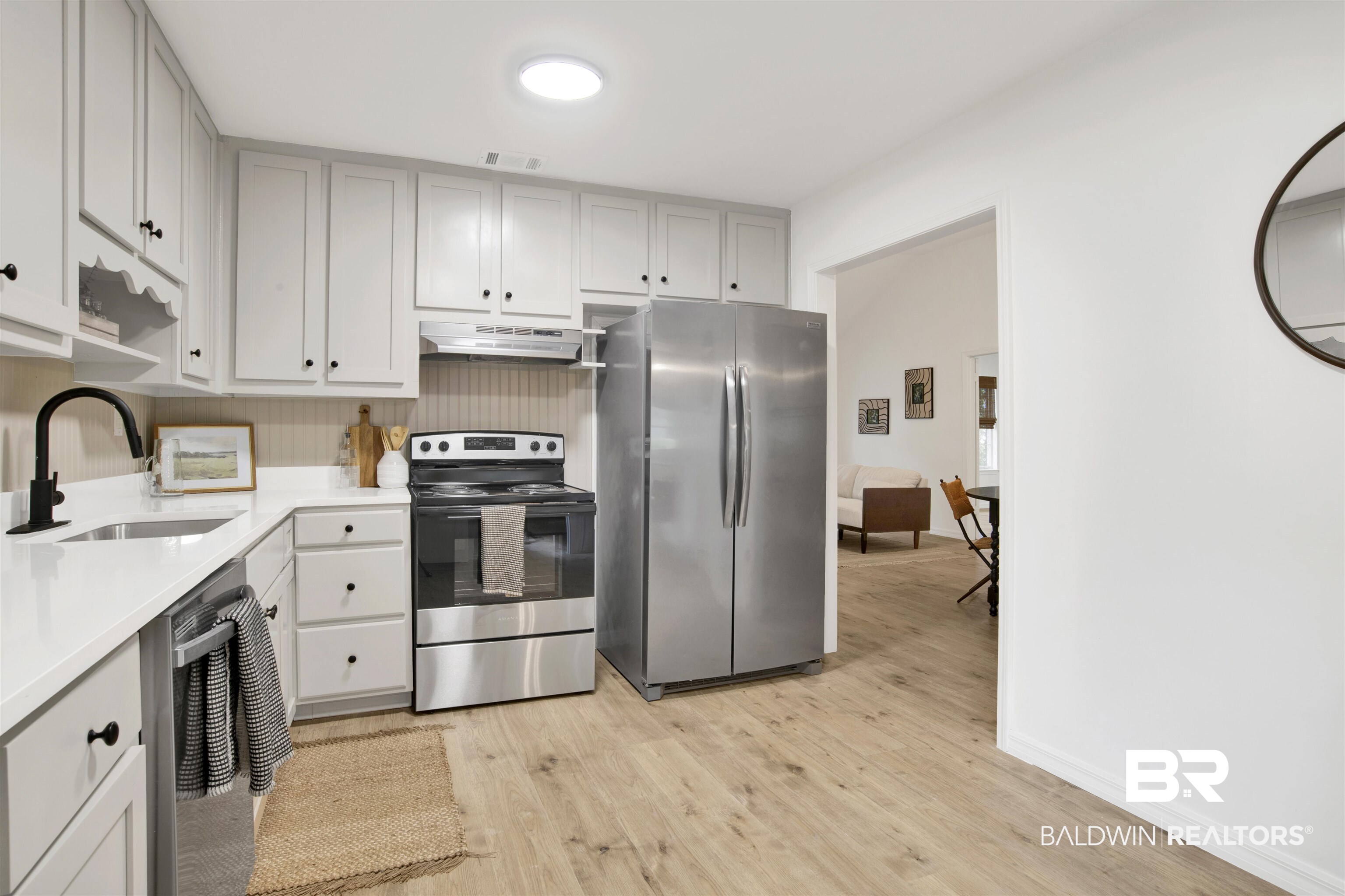 317 Lee Street Chickasaw, AL 36611 - Photo 10 of 40 Kitchen with appliances with stainless steel finishes, light countertops, light wood-style floors, and under cabinet range hood