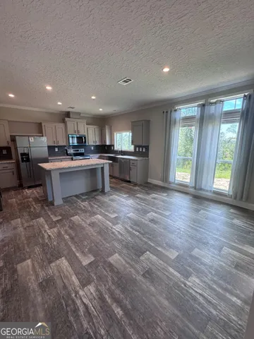 an empty room with wooden floor ceiling fan and window