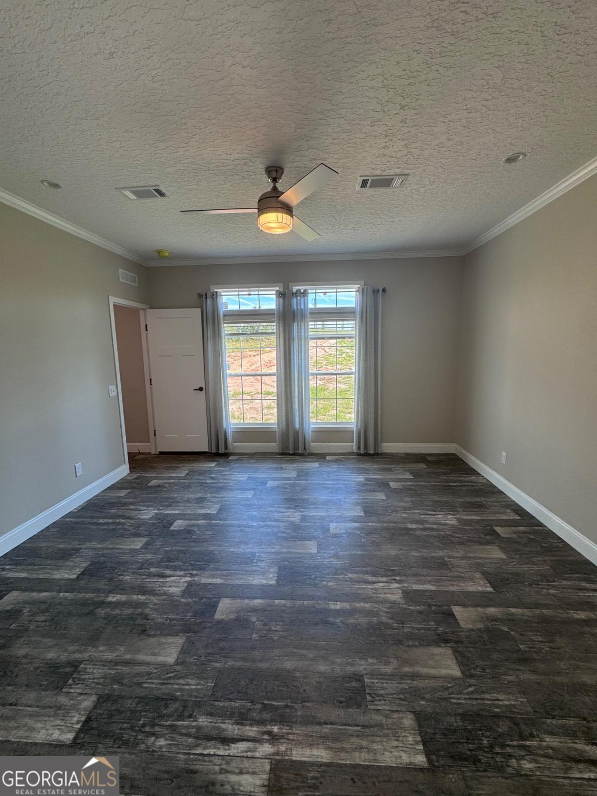 44 Long Leaf Road Hazlehurst, GA 31539 - Photo 18 of 21 an empty room with wooden floor and windows