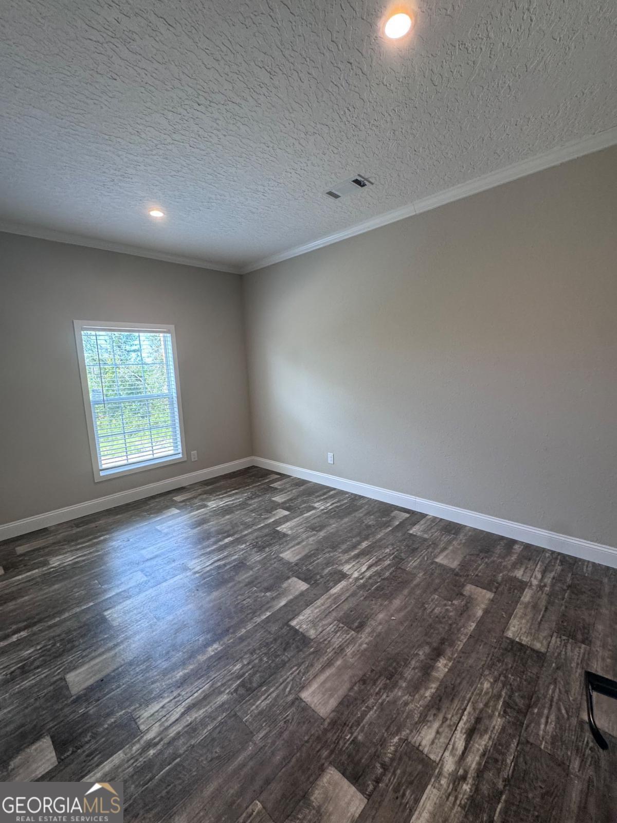 44 Long Leaf Road Hazlehurst, GA 31539 - Photo 10 of 21 an empty room with wooden floor and windows