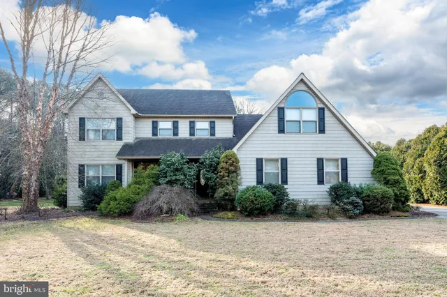 a front view of house with yard and trees around