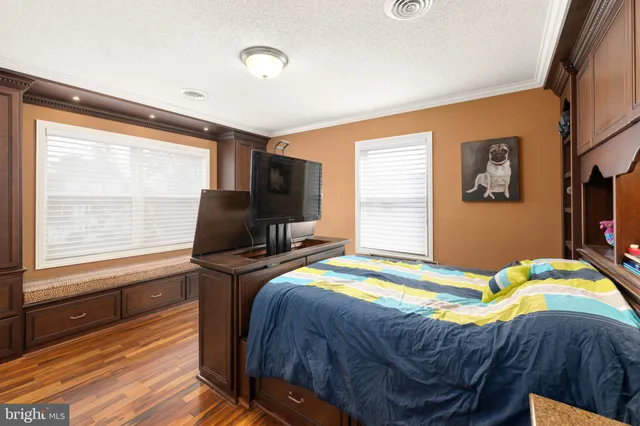 a bedroom with a bed and flat tv screen on the dresser