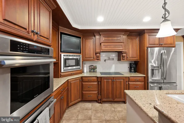 a kitchen with stainless steel appliances granite countertop a refrigerator and a stove top oven