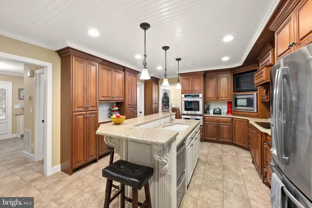 a kitchen with kitchen island a counter top space appliances and a center island