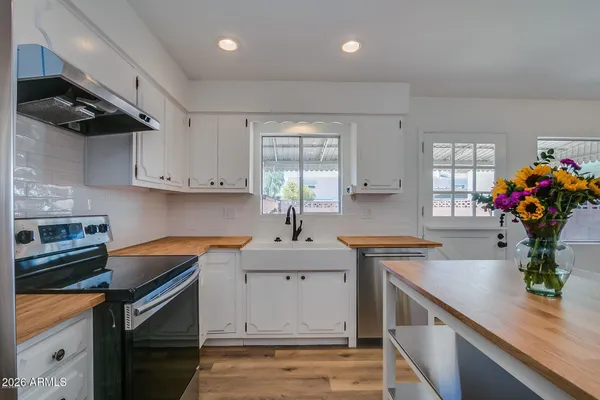 a kitchen with stainless steel appliances granite countertop a sink stove and cabinets