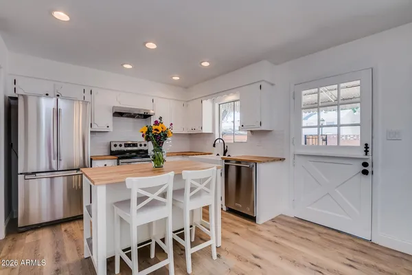a kitchen with stainless steel appliances granite countertop a refrigerator sink and cabinets