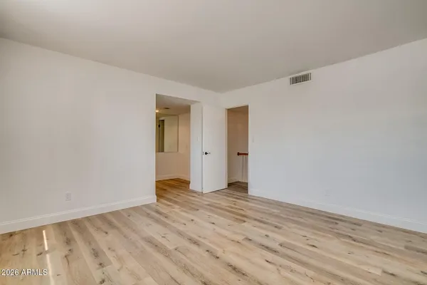a view of an empty room with wooden floor