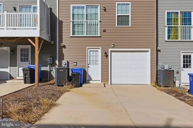 a view of a house with a barbeque and wooden fence