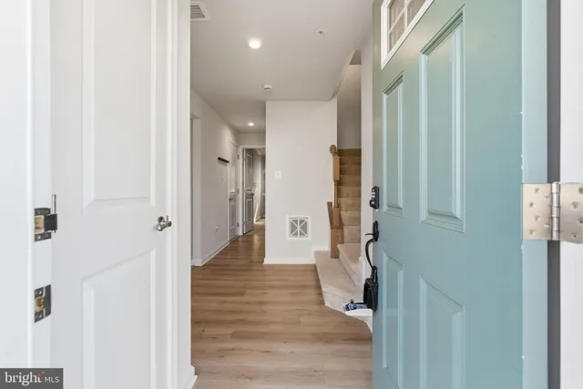 a view of a hallway with wooden floor and staircase