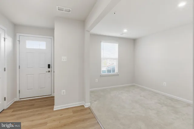 an empty room with wooden floor and window